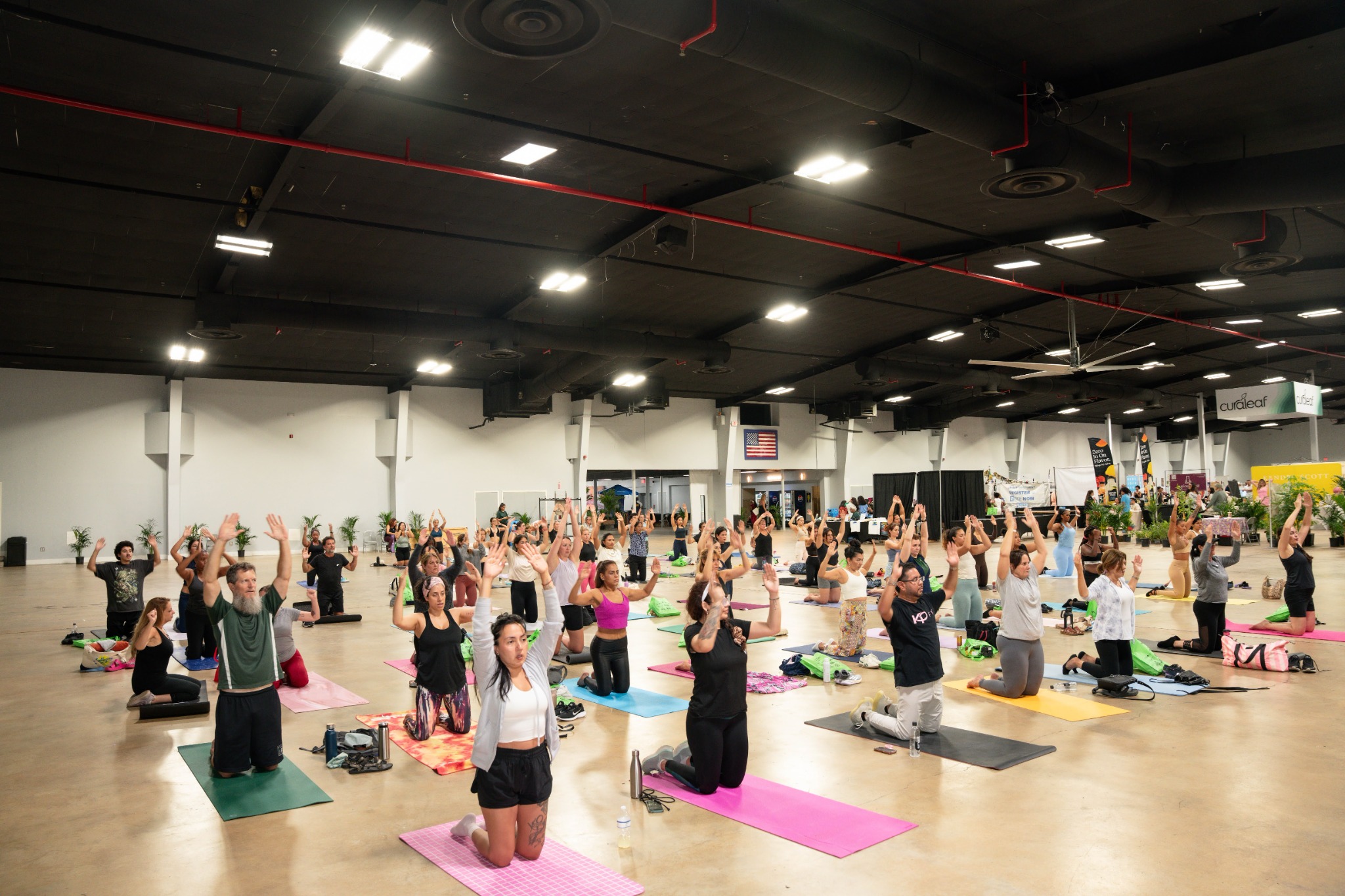 Large community Mat Pilates class led by KPFIT